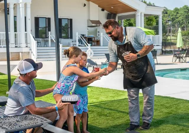 Server handing drinks to children at the Cherokee Valley community swimming pool.