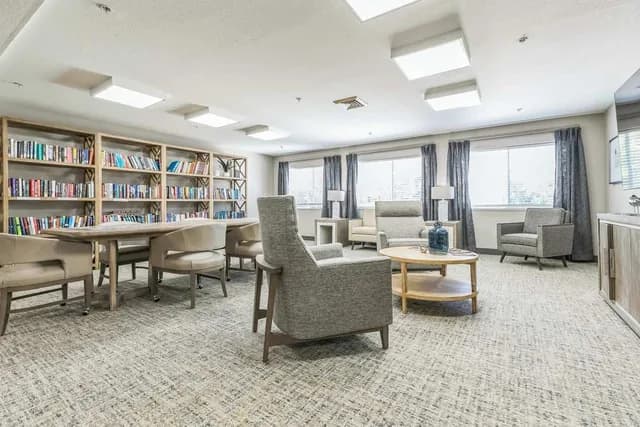 The library and reading lounge at Haywood Estates in Greenville featuring comfortable seating and bookshelves.