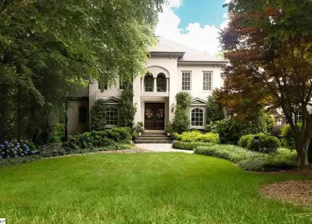 Luxury two-story stucco home with manicured lawn and lush landscaping in Montebello, Greenville, SC.