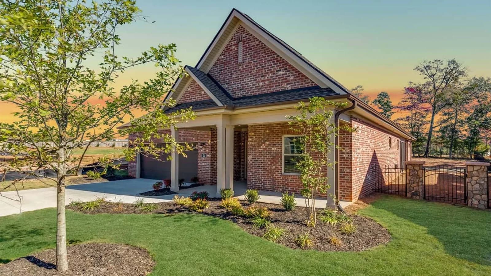 Exterior view of a modern single-story red brick home with a covered front porch in Paxton-Meadows.