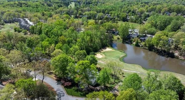 Aerial view of the Pebble Creek community in Taylors, SC, featuring the golf course, water hazards, and mature trees.