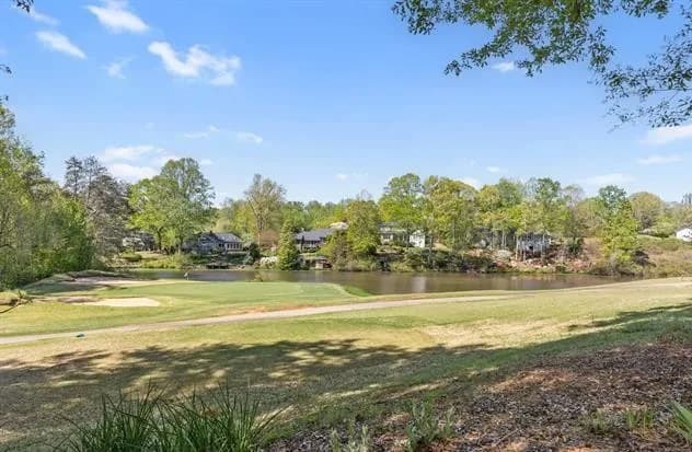 Sunny view of the golf course fairway, pond, and mature trees surrounding homes in the Pebble Creek neighborhood.