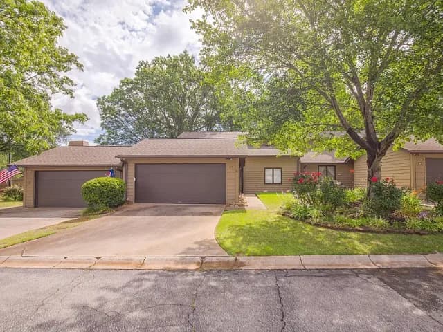 Exterior view of a single-story villa with an attached garage and manicured landscaping in Sugar Creek Villas.