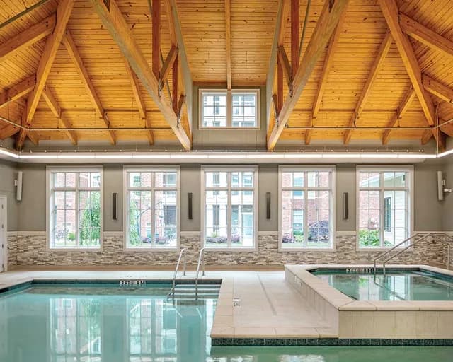 Indoor pool and hot tub at The Woodlands at Furman in Greenville, SC, featuring a vaulted wood ceiling.